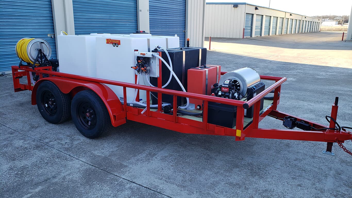 Soft wash trailer with a poly tank, black chemical tank, empty yellow hose reel and chrome blower unit, parked at a storage facility